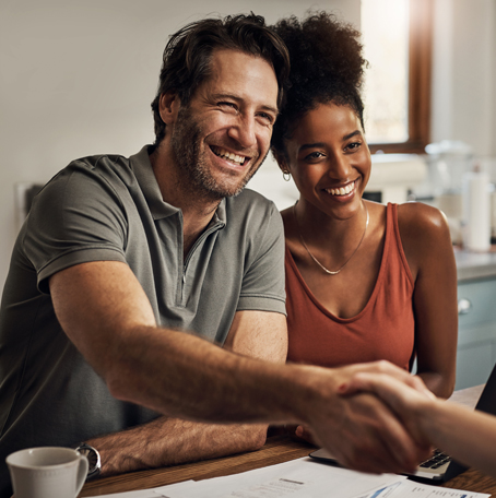 Cropped shot of middle aged couple shaking hands with a financial professional