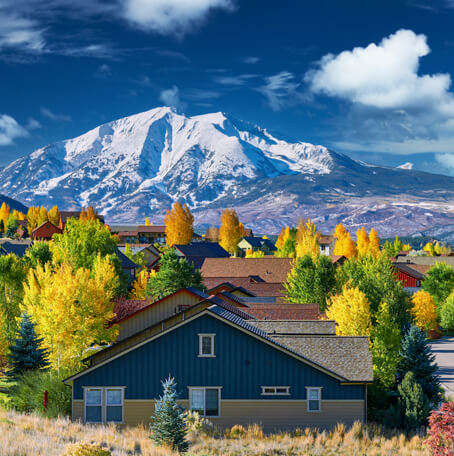 Idealic homes surrounded by beautiful fall trees with mountains in the backdrop