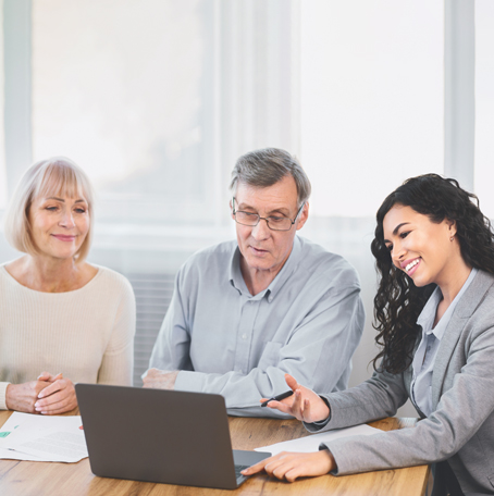 Senior couple with young loan officer reviewing detils on a laptop