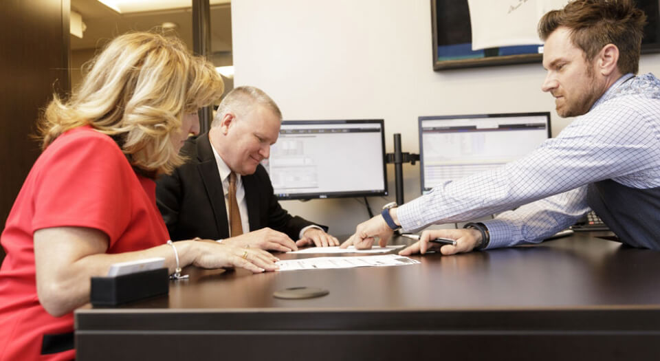 Loan Officer helping client sign documents.